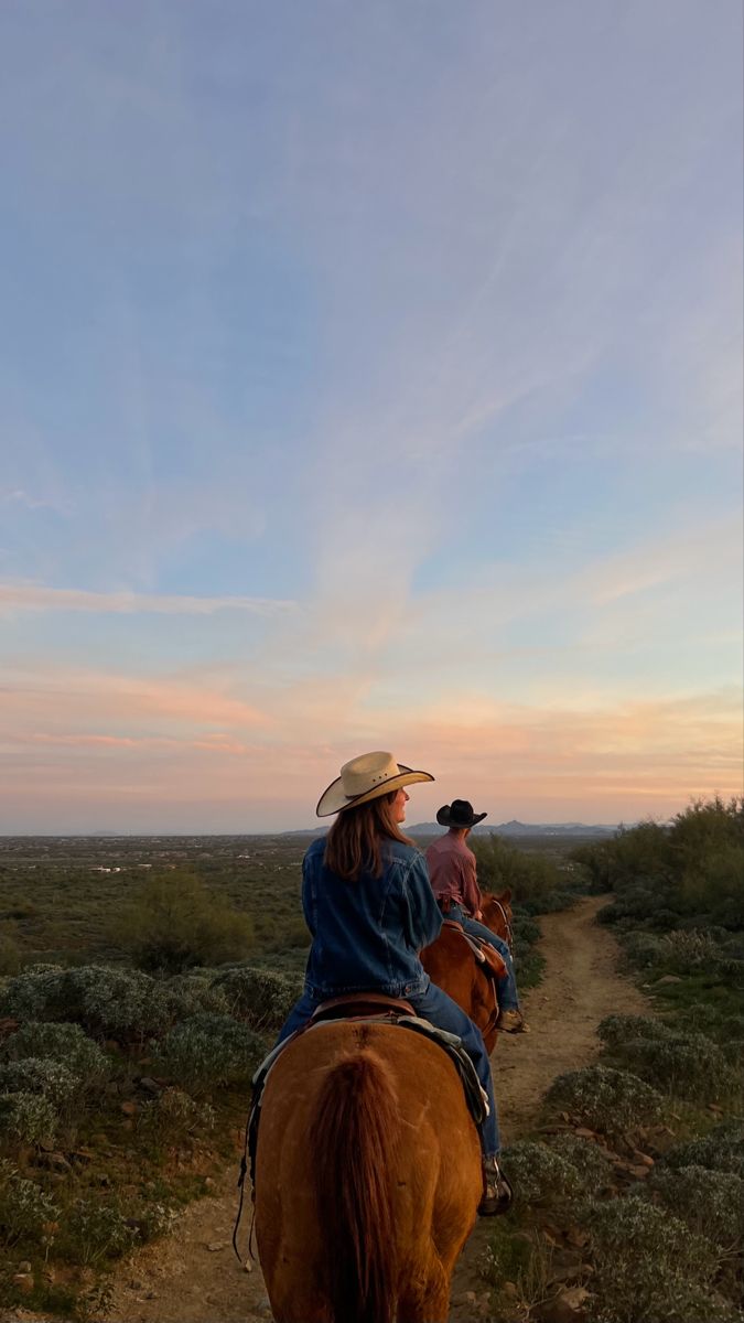 Two riders on horseback at sunset